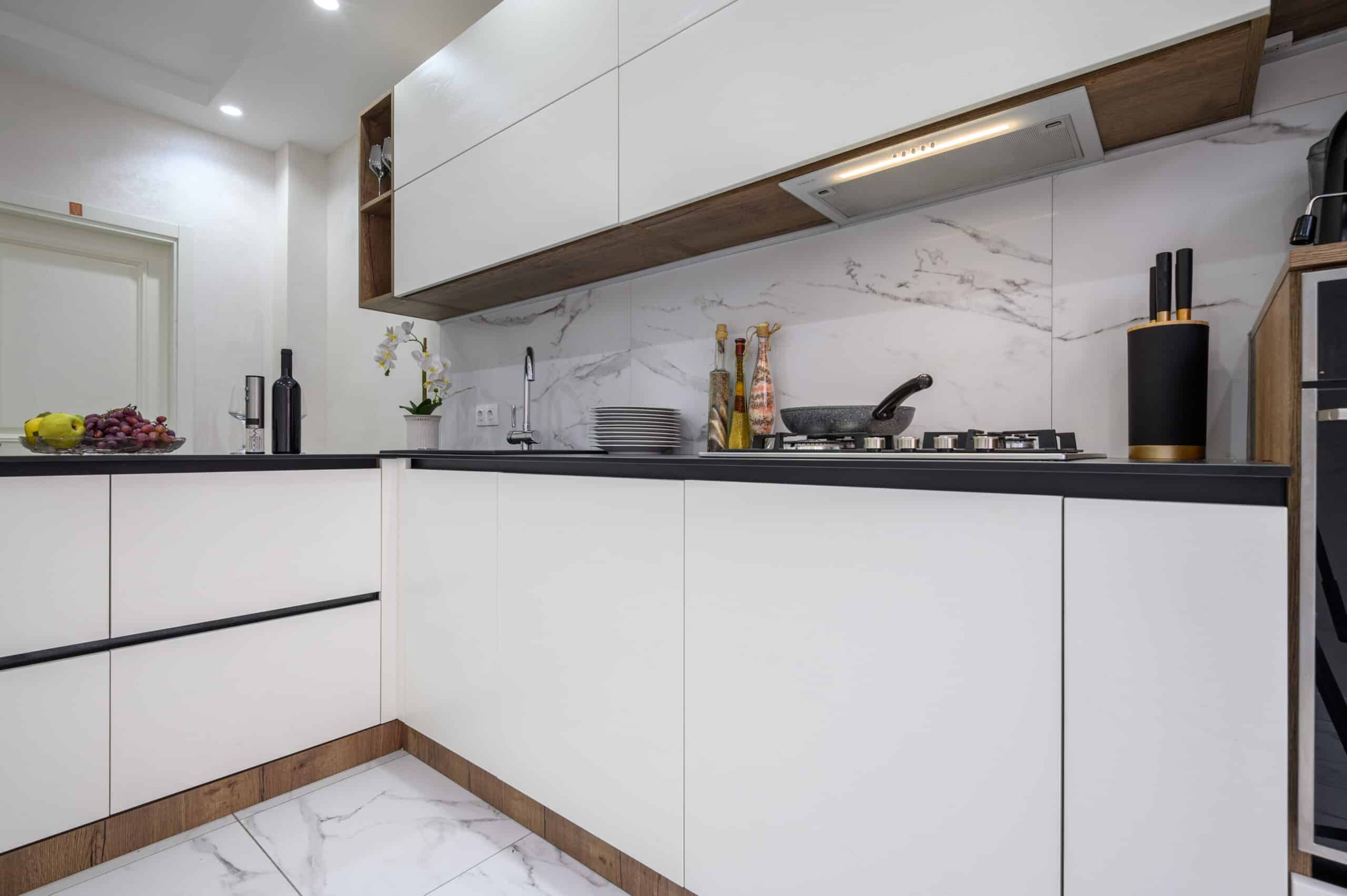 a kitchen with white cabinets and black counter tops